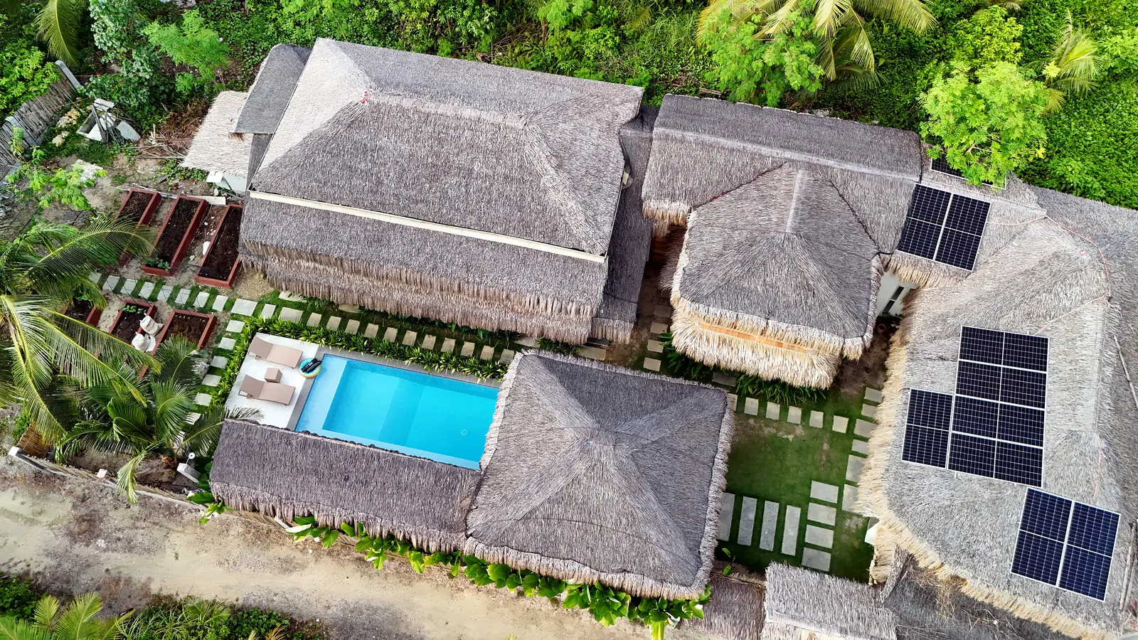 Aerial view of Terra Siargao's thatched roofs, pool and garden